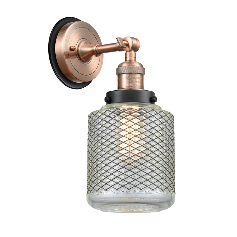 Stanton Sconce shown in the Antique Copper finish with a Clear Wire Mesh shade