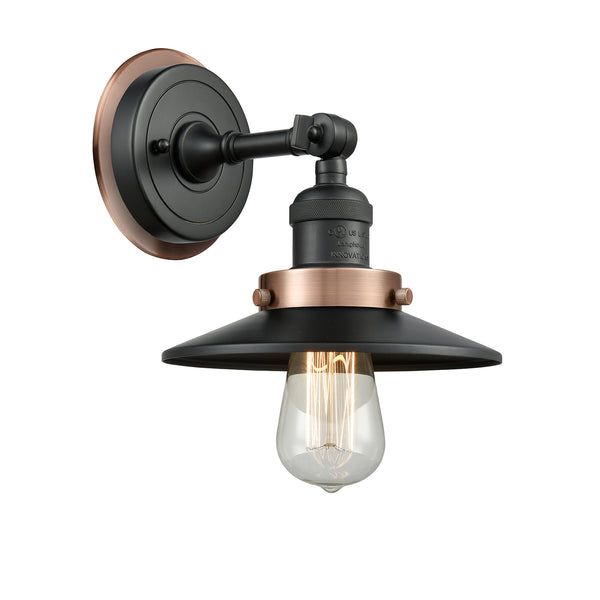 Railroad Sconce shown in the Matte Black finish with a Antique Copper shade