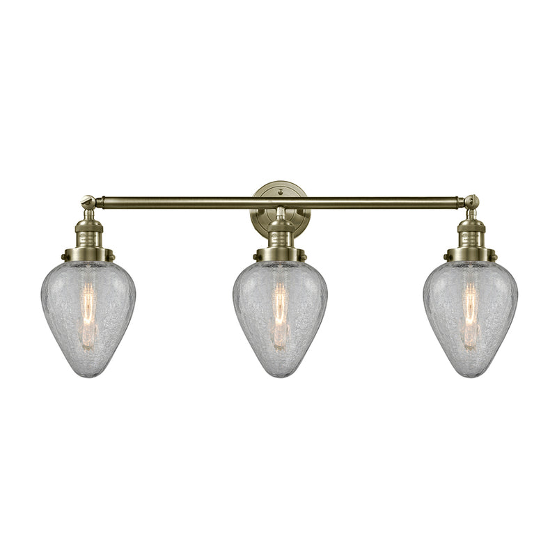 Geneseo Bath Vanity Light shown in the Antique Brass finish with a Clear Crackled shade