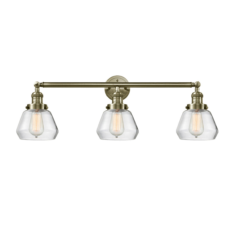 Fulton Bath Vanity Light shown in the Antique Brass finish with a Clear shade