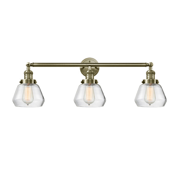 Fulton Bath Vanity Light shown in the Antique Brass finish with a Clear shade