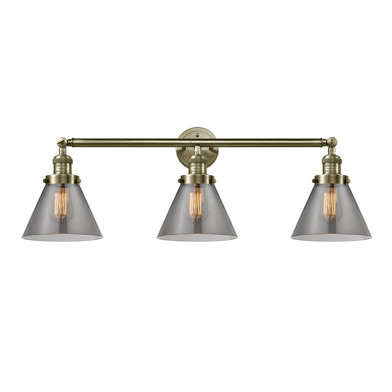 Cone Bath Vanity Light shown in the Antique Brass finish with a Plated Smoke shade