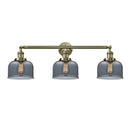 Bell Bath Vanity Light shown in the Antique Brass finish with a Plated Smoke shade