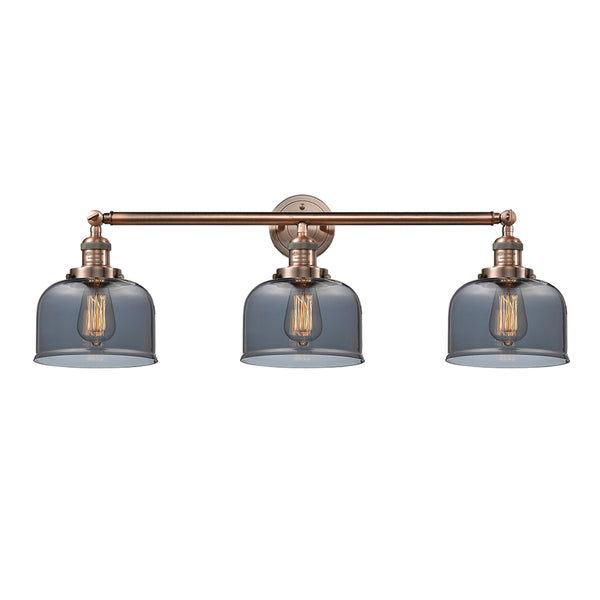 Bell Bath Vanity Light shown in the Antique Copper finish with a Plated Smoke shade