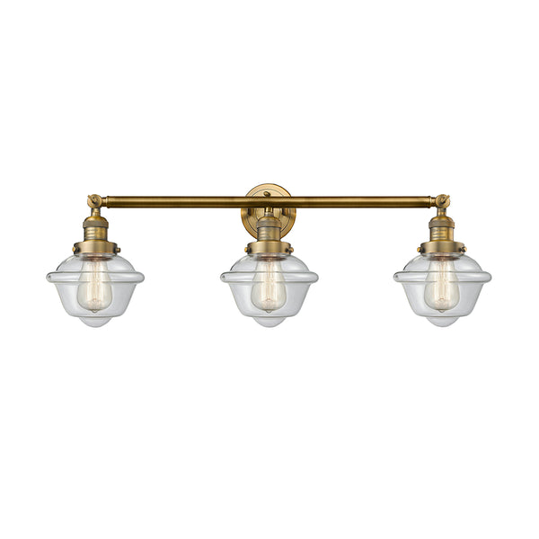 Oxford Bath Vanity Light shown in the Brushed Brass finish with a Clear shade