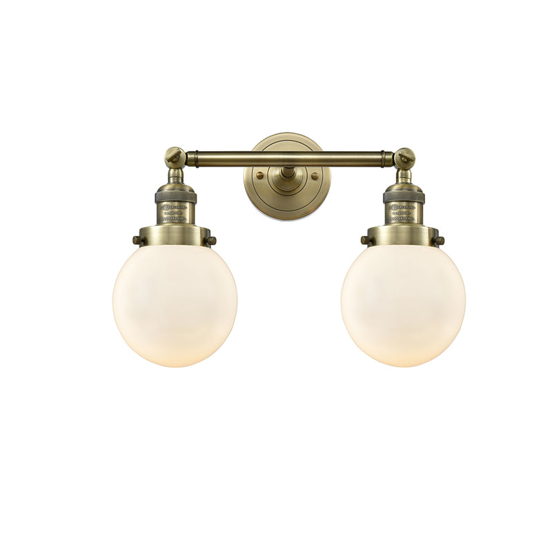 Beacon Bath Vanity Light shown in the Antique Brass finish with a Matte White shade