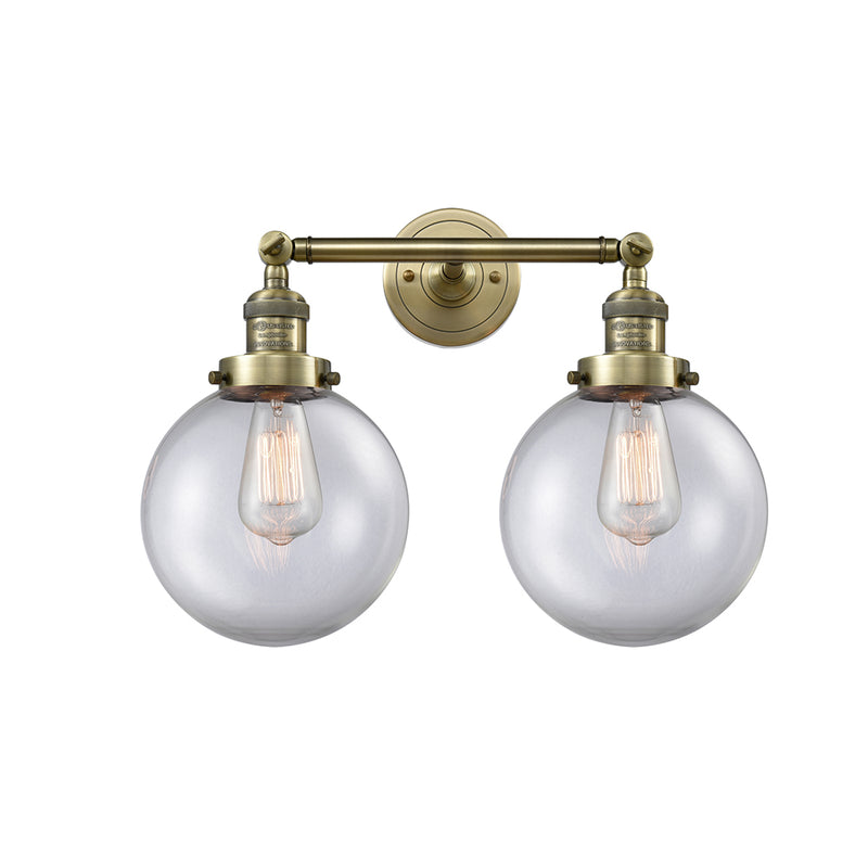 Beacon Bath Vanity Light shown in the Antique Brass finish with a Clear shade