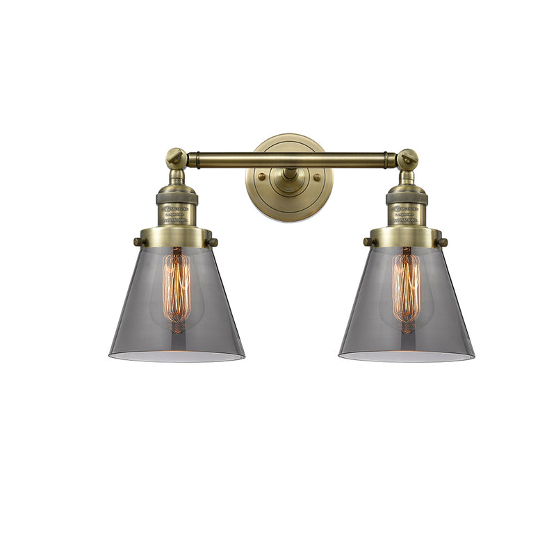 Cone Bath Vanity Light shown in the Antique Brass finish with a Plated Smoke shade