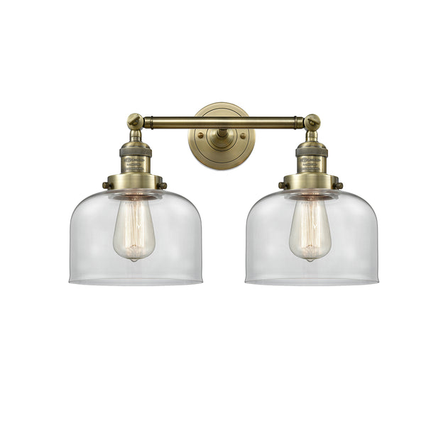 Bell Bath Vanity Light shown in the Antique Brass finish with a Clear shade