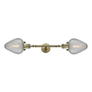 Geneseo Bath Vanity Light shown in the Antique Brass finish with a Clear Crackled shade