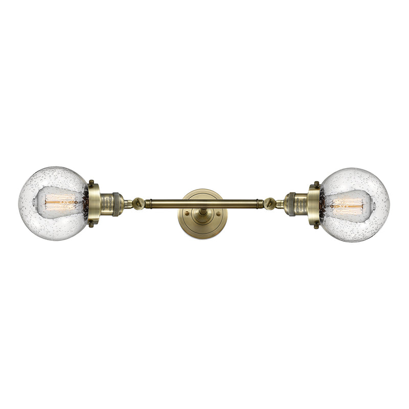 Beacon Bath Vanity Light shown in the Antique Brass finish with a Seedy shade