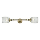 Colton Bath Vanity Light shown in the Antique Brass finish with a Clear Halophane shade