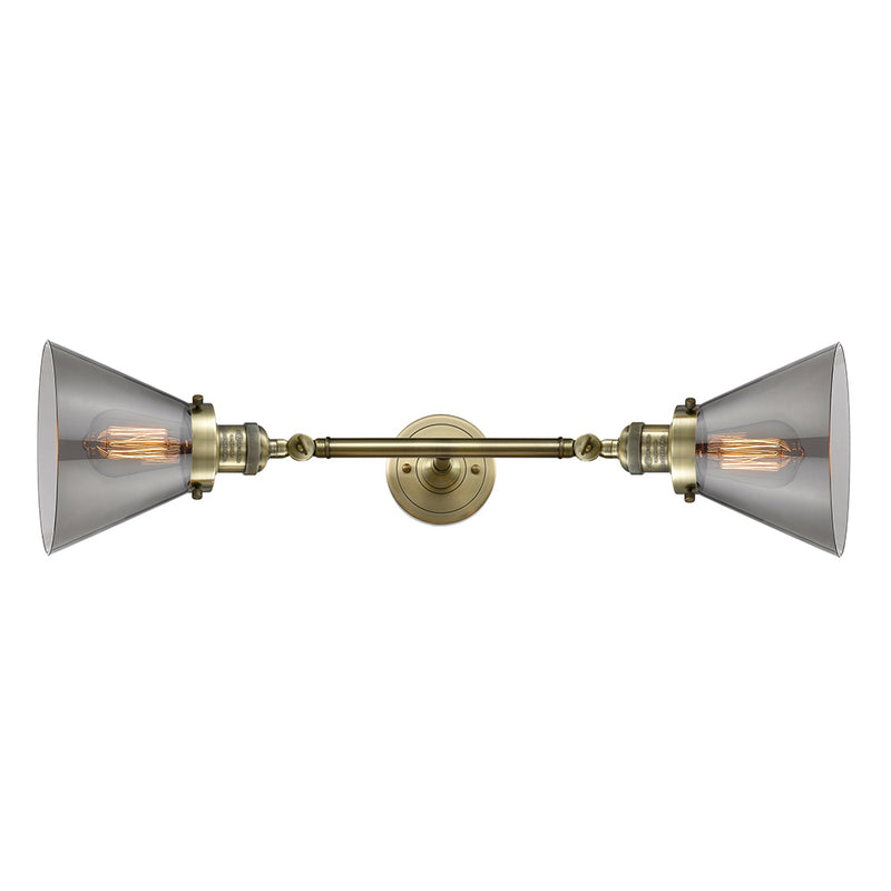 Cone Bath Vanity Light shown in the Antique Brass finish with a Plated Smoke shade