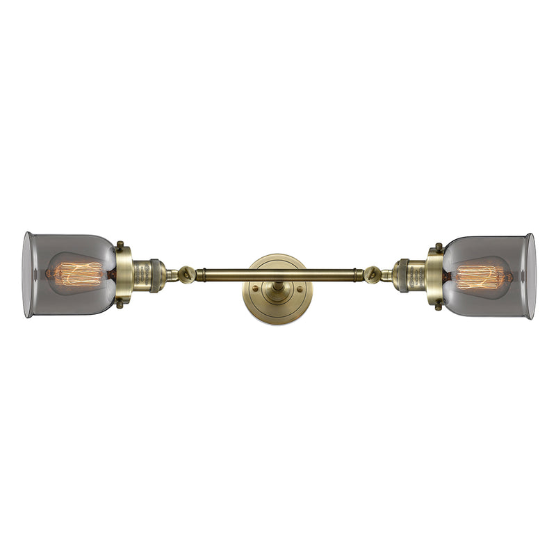 Bell Bath Vanity Light shown in the Antique Brass finish with a Plated Smoke shade