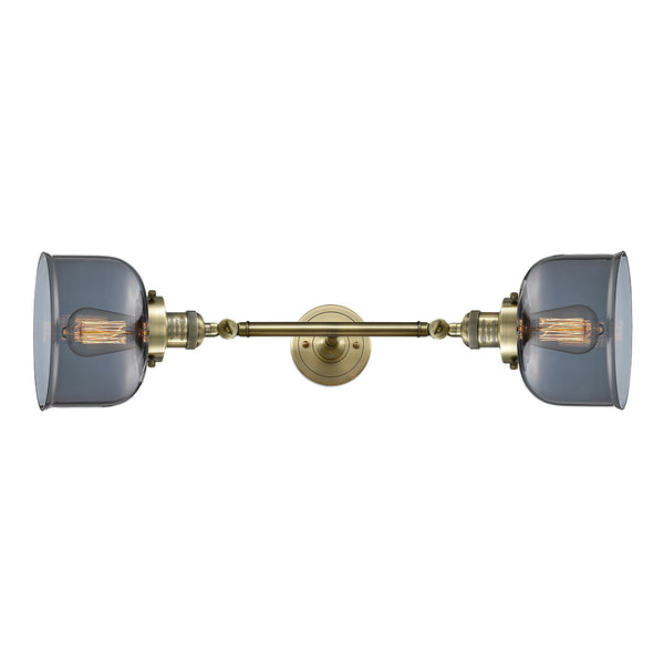 Bell Bath Vanity Light shown in the Antique Brass finish with a Plated Smoke shade