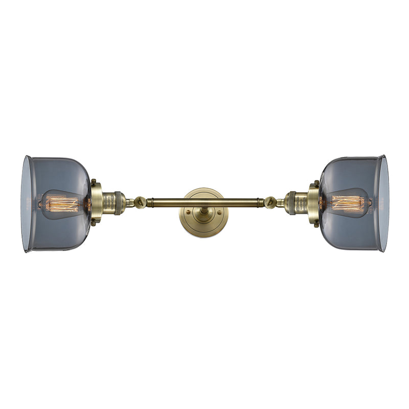 Bell Bath Vanity Light shown in the Antique Brass finish with a Plated Smoke shade