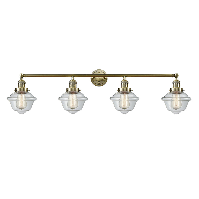 Oxford Bath Vanity Light shown in the Antique Brass finish with a Clear shade