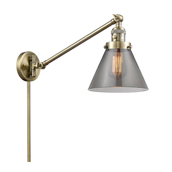 Cone Swing Arm shown in the Antique Brass finish with a Plated Smoke shade