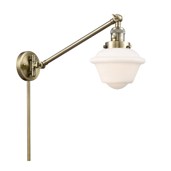 Oxford Swing Arm shown in the Antique Brass finish with a Matte White shade