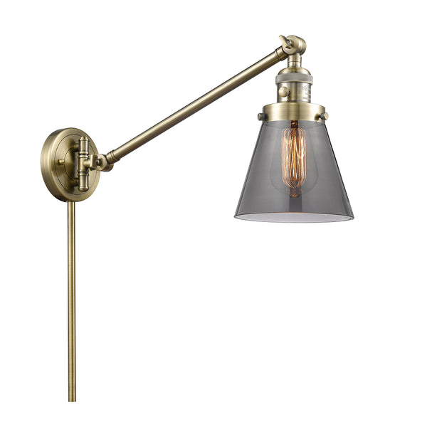 Cone Swing Arm shown in the Antique Brass finish with a Plated Smoke shade