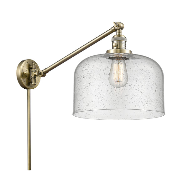 Bell Swing Arm shown in the Antique Brass finish with a Seedy shade