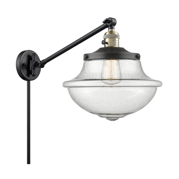 Oxford Swing Arm shown in the Black Antique Brass finish with a Seedy shade