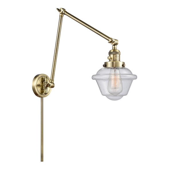 Oxford Swing Arm shown in the Antique Brass finish with a Seedy shade