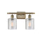 Cobbleskill Bath Vanity Light shown in the Antique Brass finish with a Clear shade