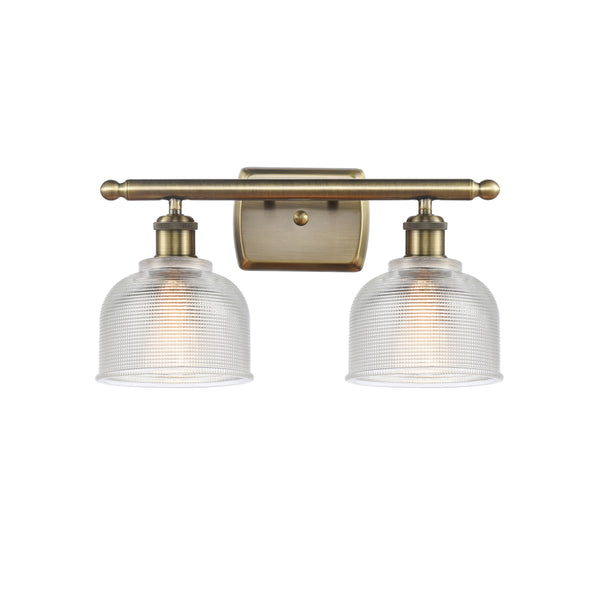 Dayton Bath Vanity Light shown in the Antique Brass finish with a Clear shade
