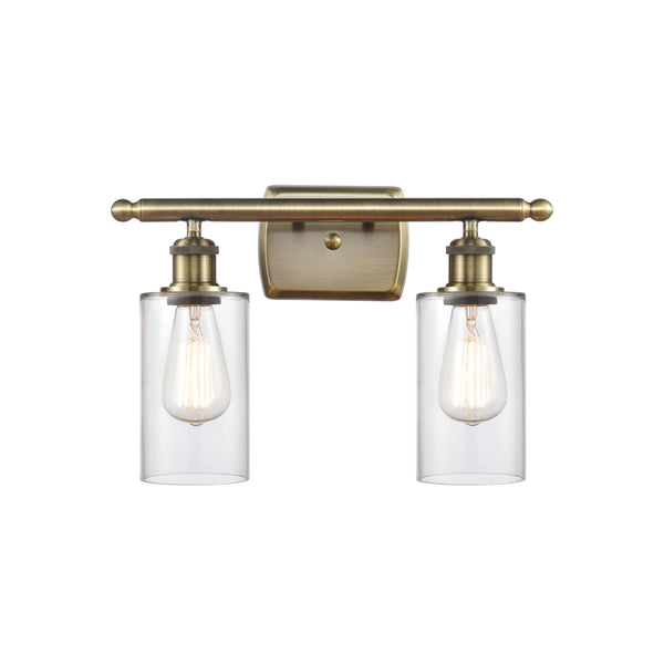 Clymer Bath Vanity Light shown in the Antique Brass finish with a Clear shade