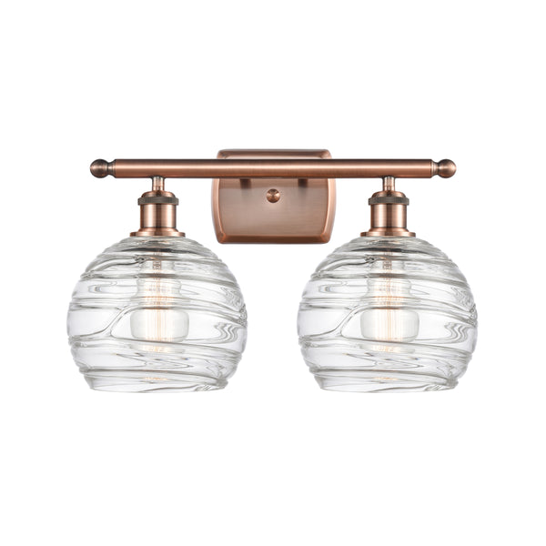 Deco Swirl Bath Vanity Light shown in the Antique Copper finish with a Clear shade