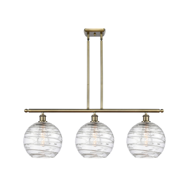 Deco Swirl Island Light shown in the Antique Brass finish with a Clear shade