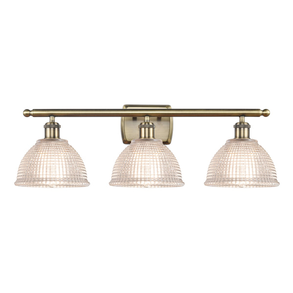 Arietta Bath Vanity Light shown in the Antique Brass finish with a Clear shade