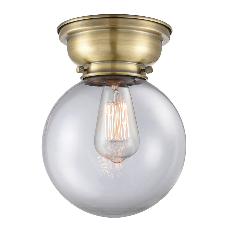 Beacon Flush Mount shown in the Antique Brass finish with a Clear shade