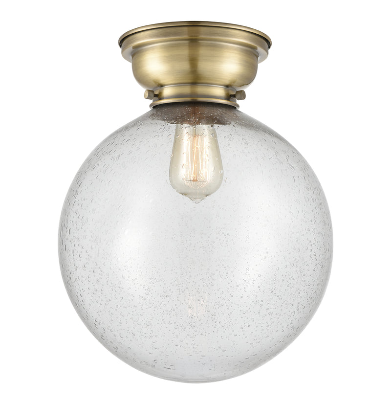 Beacon Flush Mount shown in the Antique Brass finish with a Seedy shade