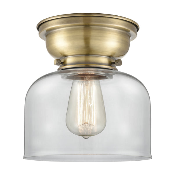 Bell Flush Mount shown in the Antique Brass finish with a Clear shade