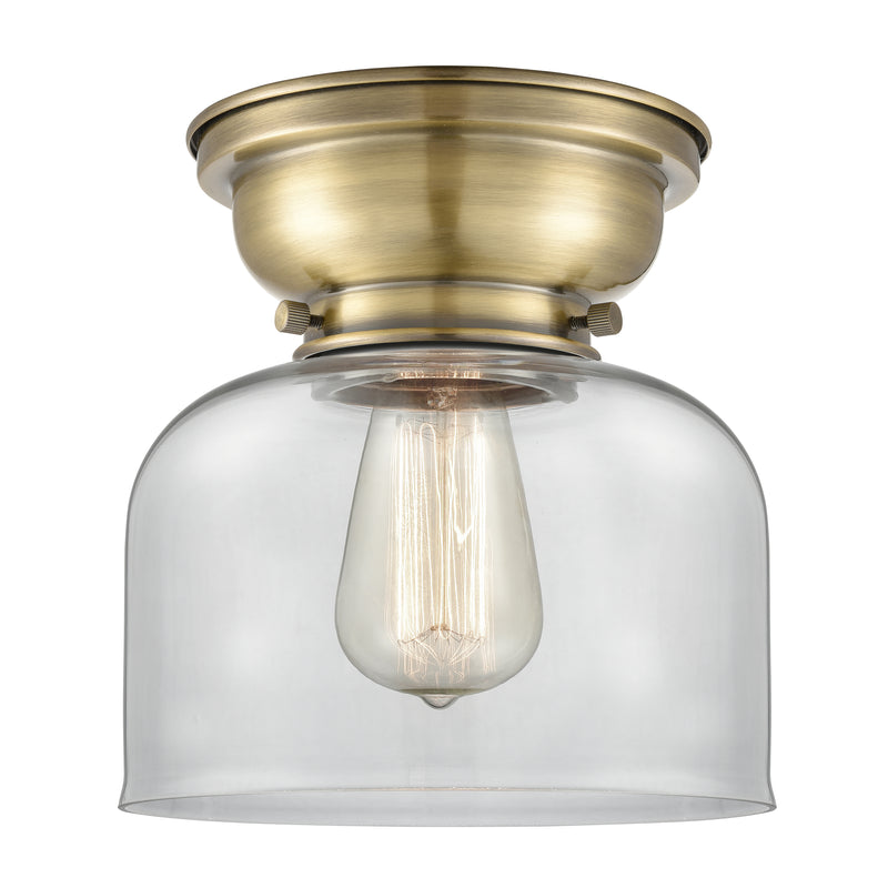Bell Flush Mount shown in the Antique Brass finish with a Clear shade